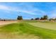 Beautifully manicured green golf course with a view of several homes in the background under a partly cloudy sky at 15046 W Cooperstown Way, Surprise, AZ 85374