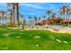 Resort-style pool area with palm trees, tables, and chairs for community members to enjoy at 15046 W Cooperstown Way, Surprise, AZ 85374