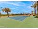 Well-maintained tennis court with an adjacent basketball hoop and seating for spectators at 15046 W Cooperstown Way, Surprise, AZ 85374