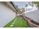 Backyard with artificial grass, a retaining wall with flowers, stepping stones and a covered patio at 15255 N 5Th Ln, Phoenix, AZ 85023
