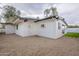 View of backyard exterior showcasing gravel ground covering, light paint color, and dark trim at 15255 N 5Th Ln, Phoenix, AZ 85023