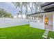Backyard with lush artificial grass, a white privacy wall, and a covered patio at 15255 N 5Th Ln, Phoenix, AZ 85023