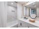 Bright bathroom with a marble tiled shower/tub and white vanity with black hardware and white countertops at 15255 N 5Th Ln, Phoenix, AZ 85023