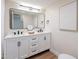 Modern bathroom featuring a double sink vanity with black hardware and stylish mirror and a wood-look floor at 15255 N 5Th Ln, Phoenix, AZ 85023