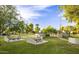 Community park equipped with picnic tables, stone benches, mature trees, and grassy areas, perfect for outdoor gatherings at 15255 N 5Th Ln, Phoenix, AZ 85023