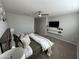 Cozy main bedroom featuring a ceiling fan, carpeted floors, and a wall-mounted TV with decorative shelves at 16049 W Alameda Rd, Surprise, AZ 85387