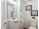 Bathroom featuring white cabinets, sink, and toilet with artwork hung on the walls at 16428 N 39Th Pl, Phoenix, AZ 85032