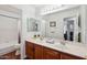 Bathroom featuring double sink with marble countertops and wood cabinets with a full tub to the left at 16428 N 39Th Pl, Phoenix, AZ 85032