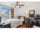 Cozy bedroom with a large window, ceiling fan, and a wooden desk with computer at 16428 N 39Th Pl, Phoenix, AZ 85032