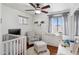 Bright Bedroom with crib, armchair, ottoman, changing table, and natural light at 16428 N 39Th Pl, Phoenix, AZ 85032