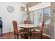 Cozy dining area with marble table, upholstered chairs, and natural light from the window at 16428 N 39Th Pl, Phoenix, AZ 85032
