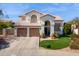 A two-story stucco house with a tile roof, a three-car garage, manicured landscaping, and an arched entryway at 16428 N 39Th Pl, Phoenix, AZ 85032