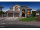 A two-story stucco house with a tile roof, a three-car garage, manicured landscaping, and an arched entryway at twilight at 16428 N 39Th Pl, Phoenix, AZ 85032