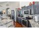 A modern kitchen with stainless steel appliances, grey cabinets, granite countertops, and hardwood floors at 16428 N 39Th Pl, Phoenix, AZ 85032