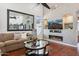 A stylish living room featuring a fireplace, hardwood floors, a modern TV, and an oversized mirror at 16428 N 39Th Pl, Phoenix, AZ 85032