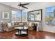 Comfortable living room with modern ceiling fan, dark wood floors, large sofa, and stone accent wall at 16428 N 39Th Pl, Phoenix, AZ 85032