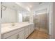 Bright bathroom featuring double sinks, a large mirror, and a glass-enclosed shower at 17264 W Via Dona Rd, Surprise, AZ 85387