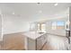 Open-concept living area showcasing a kitchen island, wood-look floors, and views of the backyard through sliding glass doors at 17264 W Via Dona Rd, Surprise, AZ 85387