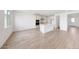 Expansive open-concept living space with wood-look tile floors, leading into the white kitchen with modern finishes at 17264 W Via Dona Rd, Surprise, AZ 85387