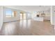 A bright open-plan living area with wood-look tile, leading to the white kitchen and sliding glass doors to the backyard at 17264 W Via Dona Rd, Surprise, AZ 85387