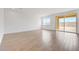 Bright and airy living room featuring wood-look tile flooring and sliding glass doors providing access to the backyard at 17264 W Via Dona Rd, Surprise, AZ 85387