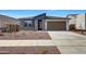 Inviting single-story home featuring a neutral color palette, two-car garage, and low-maintenance desert landscaping at 17295 W Via Dona Rd, Surprise, AZ 85387