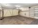 Spacious garage with bright lighting, shelving units, and a functional garage door at 17437 N 41St Dr, Glendale, AZ 85308