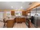 Bright kitchen featuring wood cabinets, stainless steel appliances, and a cozy breakfast bar at 17437 N 41St Dr, Glendale, AZ 85308