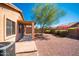 A backyard with gravel landscaping, desert plants, and covered patio offer a relaxed outdoor living space at 17633 W Wind Song Ave, Goodyear, AZ 85338
