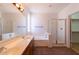 Bathroom featuring double sinks, a bathtub, a shower with glass door, and a neutral color palette at 17633 W Wind Song Ave, Goodyear, AZ 85338