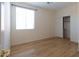Bedroom featuring light wood floors, a closet, and a window with natural light at 17633 W Wind Song Ave, Goodyear, AZ 85338