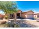 Well-kept home with desert landscaping and a two-car garage on a sunny day at 17633 W Wind Song Ave, Goodyear, AZ 85338