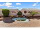 Backyard water feature with natural rock accents set amongst brick-paved patio and desert landscaping at 17643 W Weatherby Dr, Surprise, AZ 85374