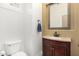 Powder room featuring a vanity with granite counters, a decorative mirror, and a toilet at 19550 N Grayhawk Dr # 1044, Scottsdale, AZ 85255