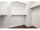 This walk-in closet features built-in shelving and wooden poles for efficient storage at 19550 N Grayhawk Dr # 1044, Scottsdale, AZ 85255
