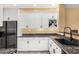Bright kitchen with white cabinets, black appliances, and granite countertops at 19550 N Grayhawk Dr # 1044, Scottsdale, AZ 85255