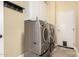 Laundry room featuring a front-load washer and dryer, white cabinets, and a pet door at 19550 N Grayhawk Dr # 1044, Scottsdale, AZ 85255
