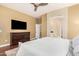 The primary bedroom features wood floors, large TV, an ensuite bathroom, and an arched doorway at 19550 N Grayhawk Dr # 1044, Scottsdale, AZ 85255