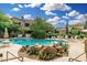 A luxurious community pool with a waterfall, lounge seating, and mature trees at 19550 N Grayhawk Dr # 1044, Scottsdale, AZ 85255