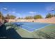 Community tennis court with lights and a viewing bench surrounded by a decorative privacy wall at 19550 N Grayhawk Dr # 1044, Scottsdale, AZ 85255