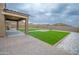 Backyard featuring artificial turf, gravel, a paved walkway, and a covered patio at 25437 W Mahoney Ave, Buckeye, AZ 85326