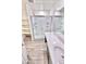 Modern bathroom with a glass-enclosed shower, laminate floors, and a white vanity with generous counter space at 25437 W Mahoney Ave, Buckeye, AZ 85326