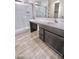 Bathroom featuring a glass-enclosed shower, wood-look floors, and a double sink vanity with plentiful storage space at 25437 W Mahoney Ave, Buckeye, AZ 85326
