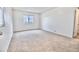 Bright, neutral-carpeted bedroom featuring a window and access to the ensuite bathroom, offering a clean, modern design at 25437 W Mahoney Ave, Buckeye, AZ 85326