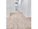Hallway featuring carpet, white walls, white trim, and two doors at 25437 W Mahoney Ave, Buckeye, AZ 85326