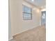 Well-lit hallway featuring neutral carpet and a window with blinds, offering a bright and airy feel at 25437 W Mahoney Ave, Buckeye, AZ 85326