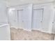 Hallway featuring carpet, white walls, white trim, and three doors at 25437 W Mahoney Ave, Buckeye, AZ 85326
