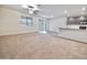 A spacious living room with a ceiling fan and access to a kitchen at 25437 W Mahoney Ave, Buckeye, AZ 85326