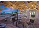 Charming backyard with a pergola, pool views, outdoor seating, and ambient lighting for evening enjoyment at 25454 N 73Rd Ave, Peoria, AZ 85383