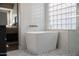 Bright bathroom featuring a contemporary freestanding tub, mosaic tile floor and glass block window at 25454 N 73Rd Ave, Peoria, AZ 85383